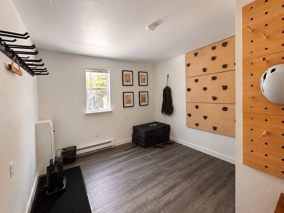 Dedicated gear room with climbing wall, storage racks, and workout space