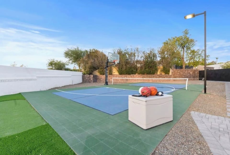 A full sport court with basketball hoop and cooler stands ready for game day.