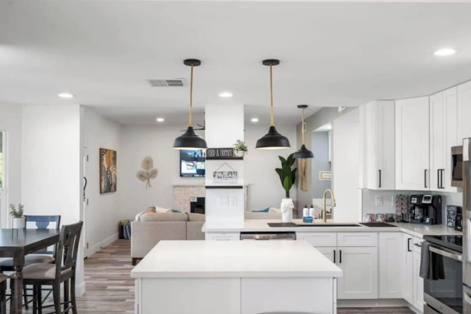 Chef's kitchen with large island, pendant lighting, and seamless flow into living and dining areas.