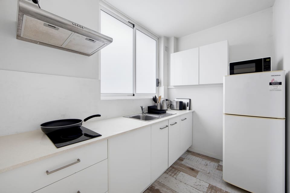 Kitchen with stovetop, fridge, and microwave