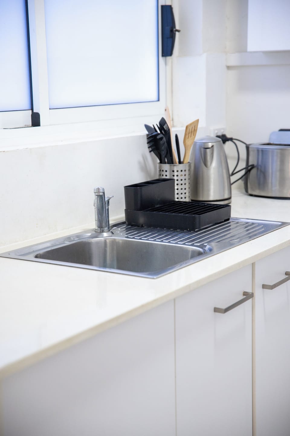Kitchen sink with kettle and utensils