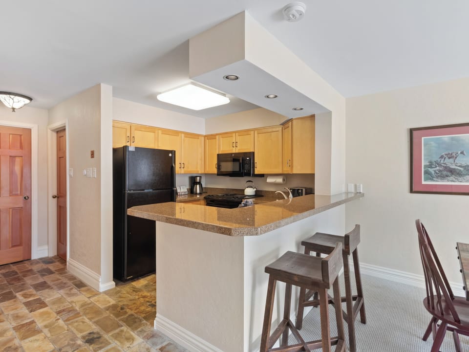 Kitchen with 2 Barstools up to Kitchen Island
