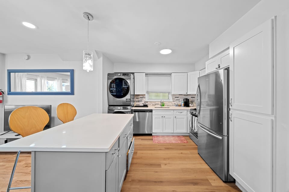 Bright modern kitchen with large island, stainless appliances & in-unit laundry