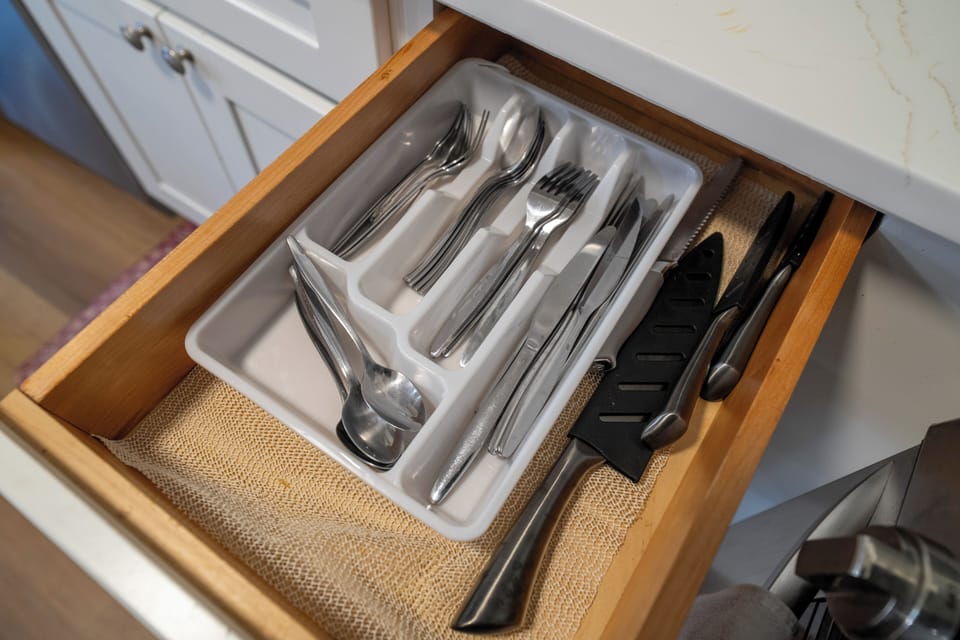 Well-stocked kitchen drawer with organized flatware and cooking essentials