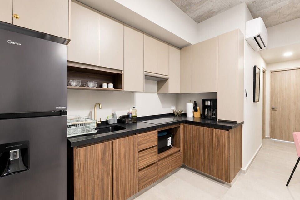 Cocina equipada con estufa, microondas, refrigerador y todos los utensilios necesarios para preparar tus comidas con facilidad.