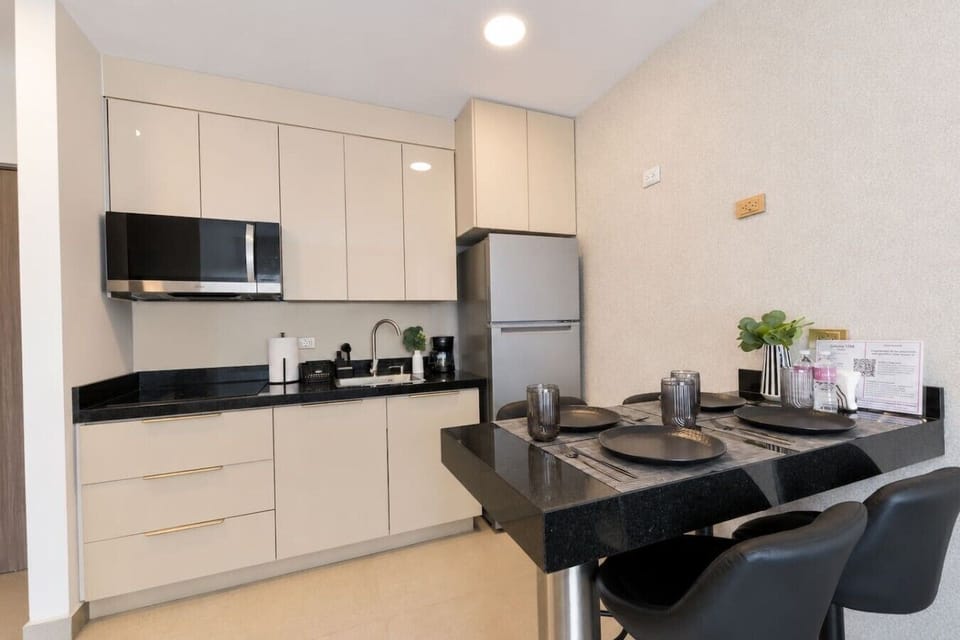 Cocina equipada con estufa, cafetera, licuadora y utensilios de cocina, ideal para preparar tus alimentos cómodamente durante tu estancia.