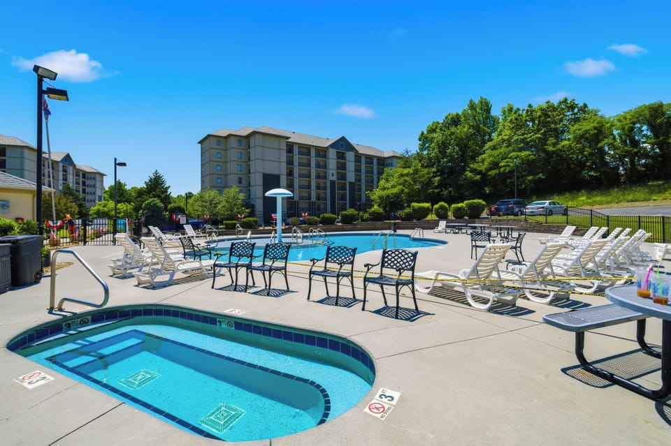Resort-style outdoor pool with kiddie pool and plenty of sunny lounge seating