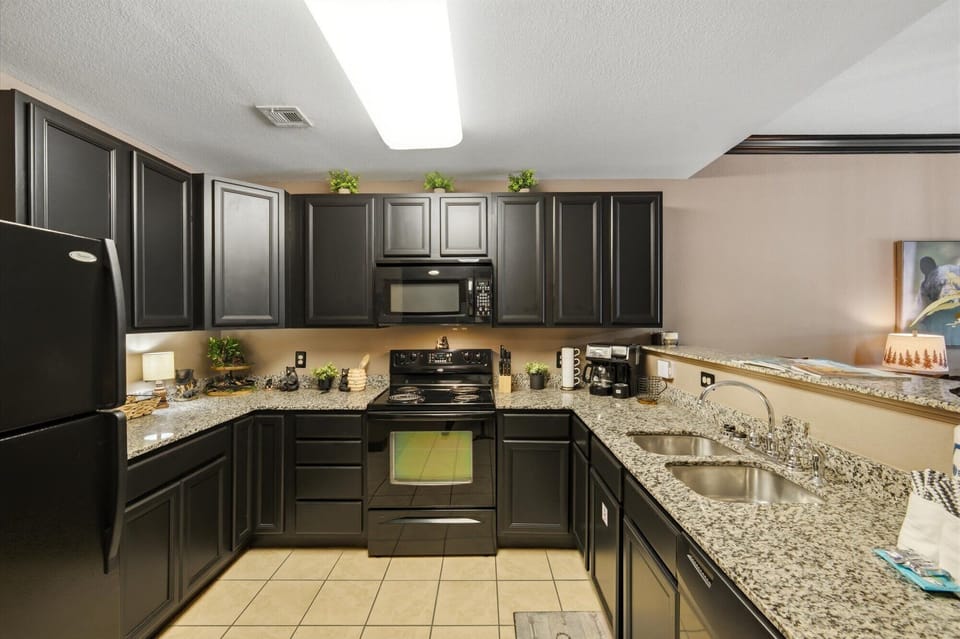 Modern granite kitchen with spacious counters and full appliances