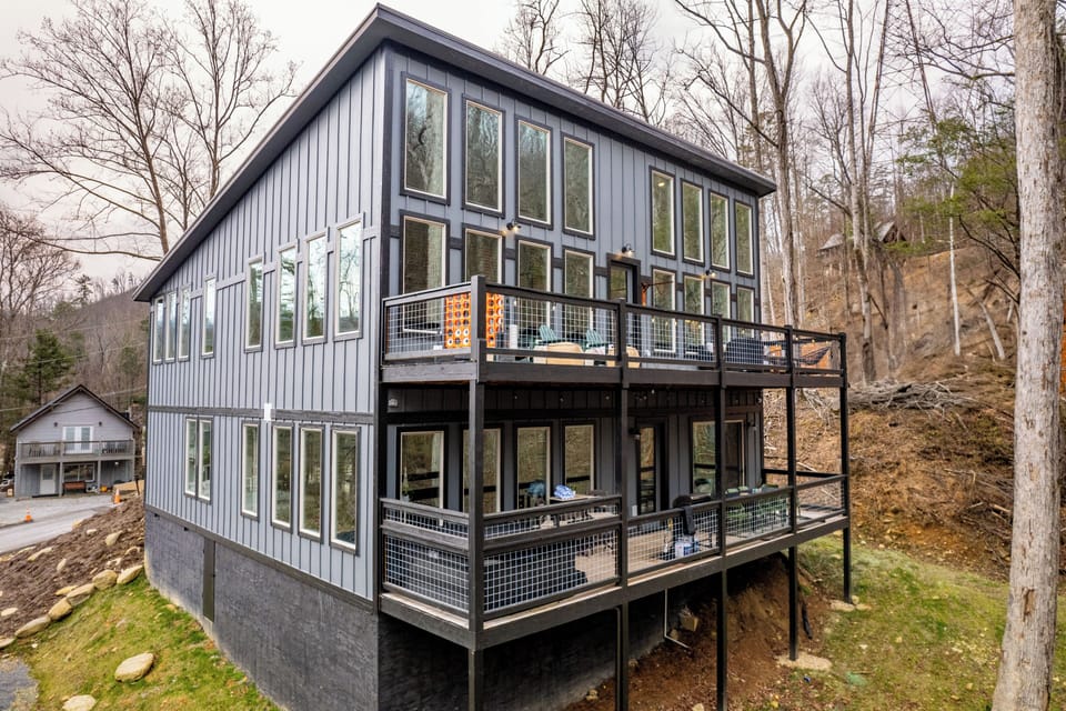 Modern hillside retreat with panoramic windows and two scenic decks