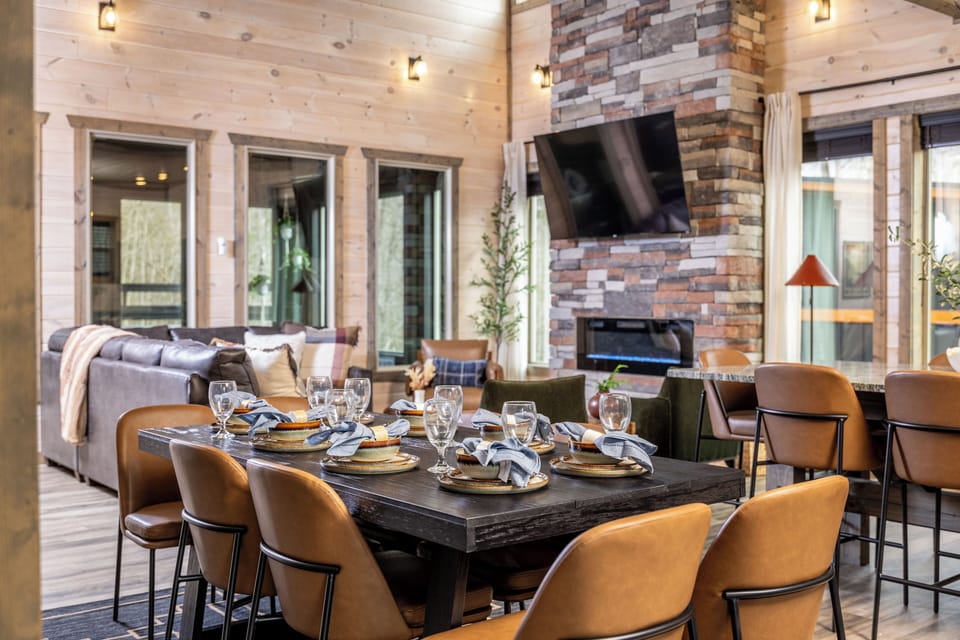 Warm mountain-modern great room with fireplace, TV, and spacious dining