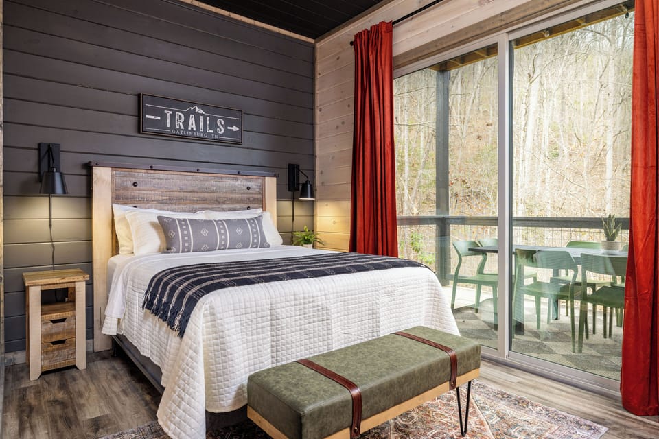 Cozy rustic bedroom with private patio and serene wooded views