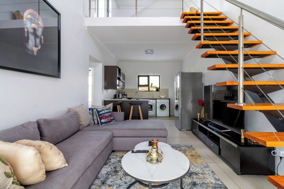 Modern loft: open kitchen, washer/dryer, floating stairs, chic lounge