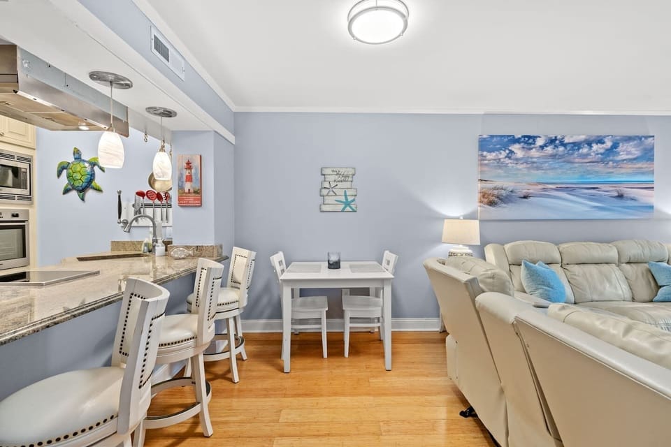 Coastal-chic living with breakfast bar, hardwood floors, and plush sofa