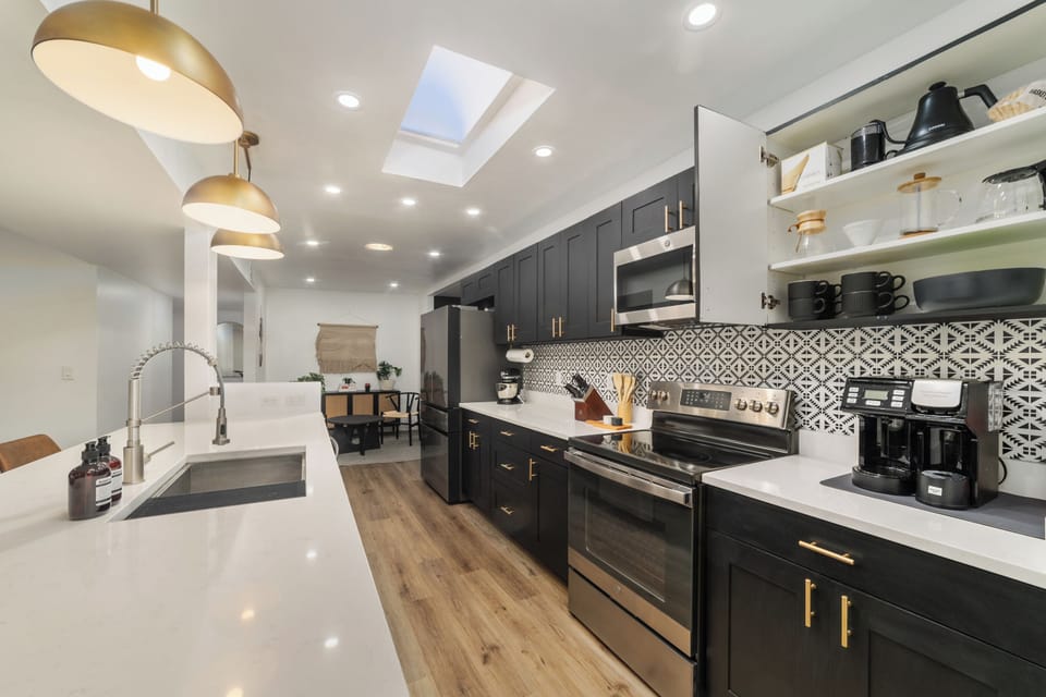 Bright modern kitchen with quartz counters, skylight, and stylish finishes