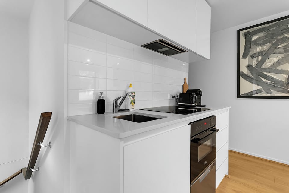 Bright modern kitchenette with sleek finishes and built-in appliances