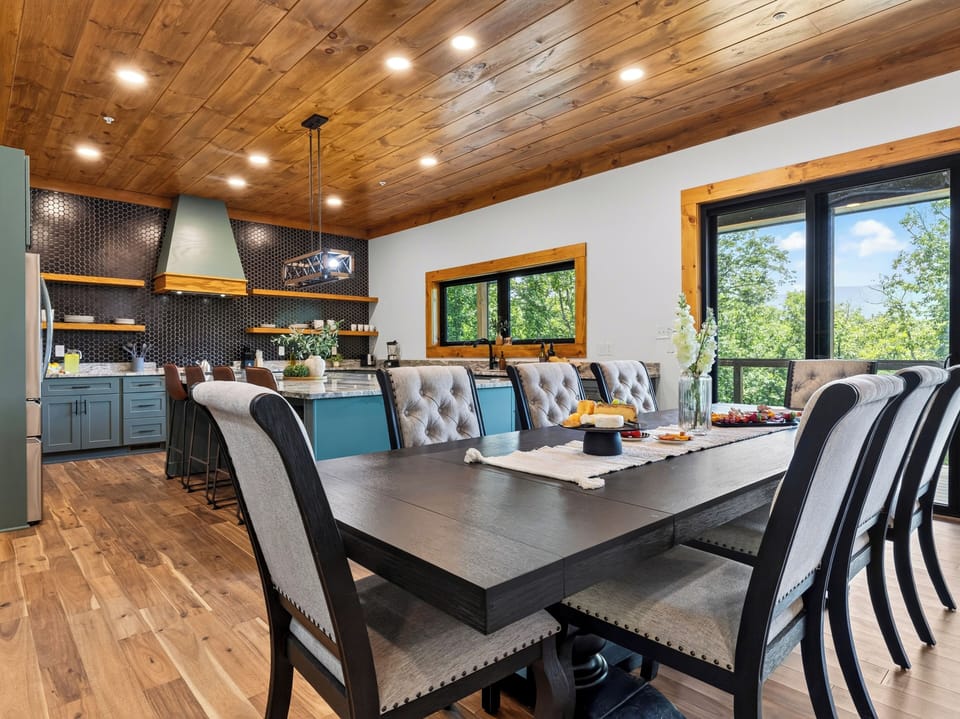 Elegant formal dining table with seating for ten, looking toward the open kitchen.