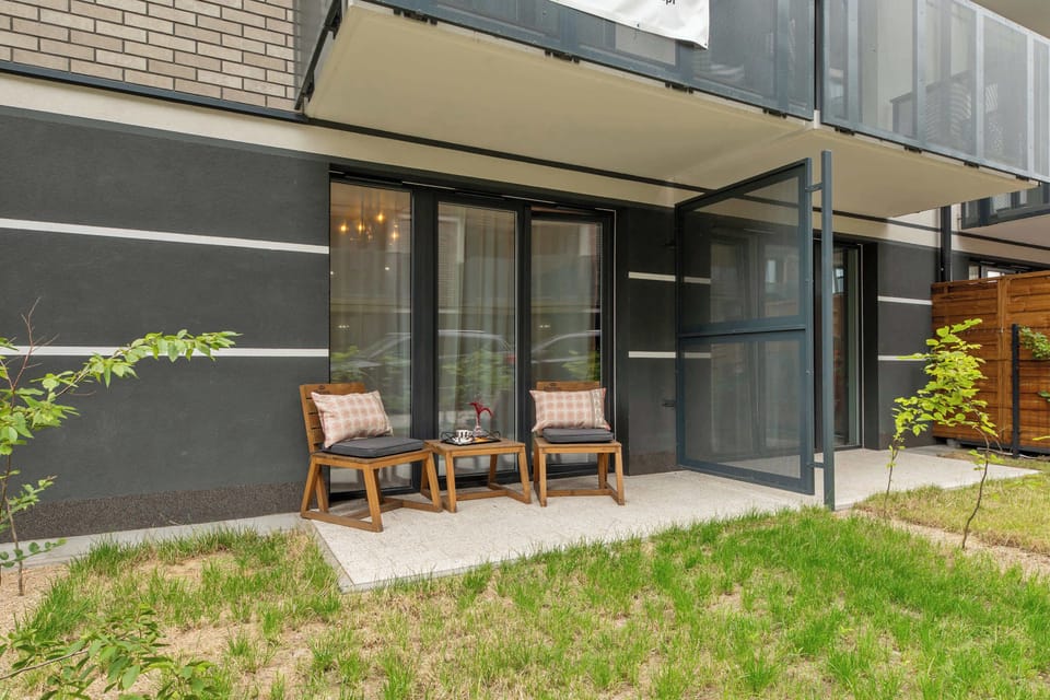 Dużym atutem apartamentu jest bezpośrednie wyjście na taras z ogródkiem. Przestrzeń została wyposażona w meble ogrodowe, dzięki czemu goście mogą komfortowo odpocząć na świeżym powietrzu.