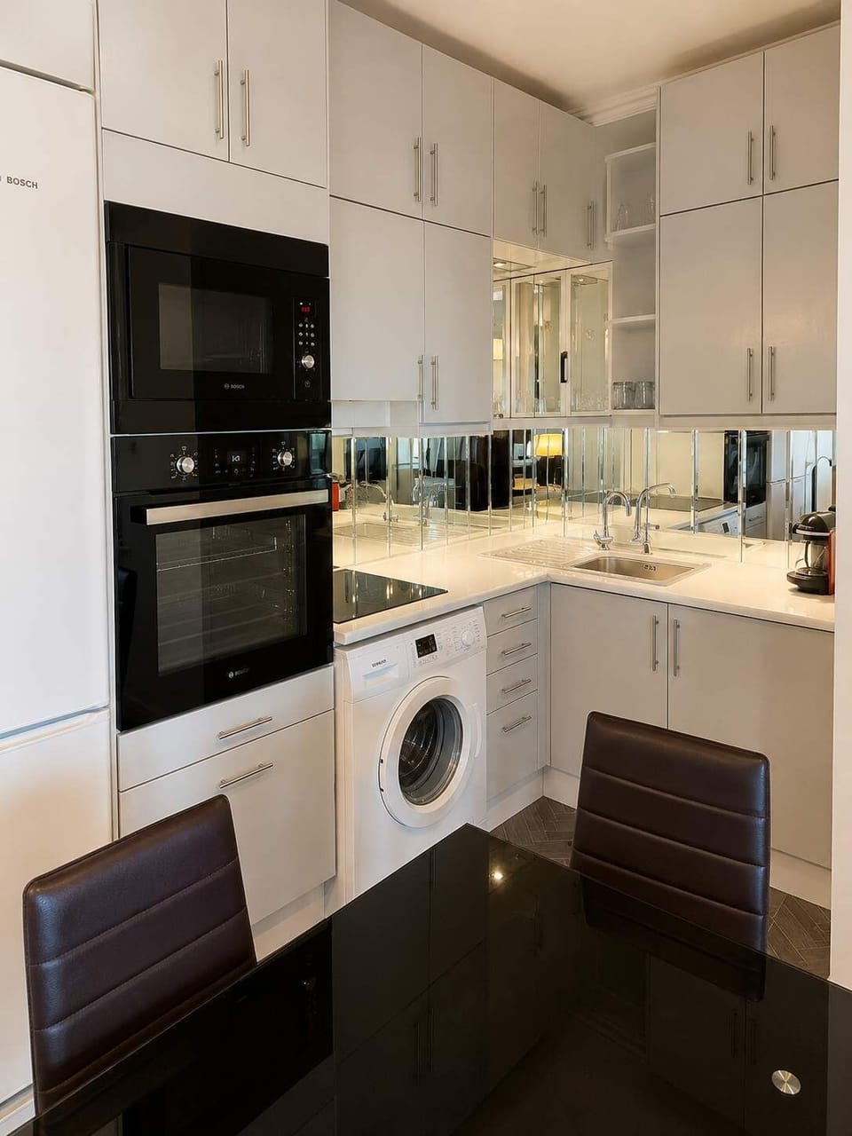 Fully equipped modern kitchen with oven, microwave, washing machine and dining area