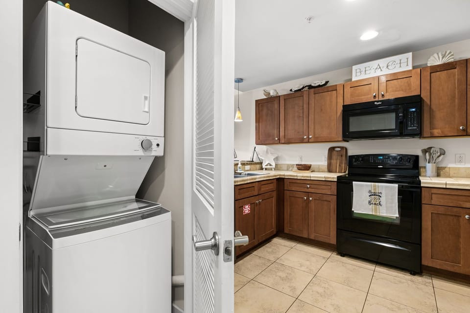 Your fully equipped kitchen awaits, complete with warm wood cabinetry, modern appliances, and convenient in-unit laundry—everything you need to feel right at home during your stay.