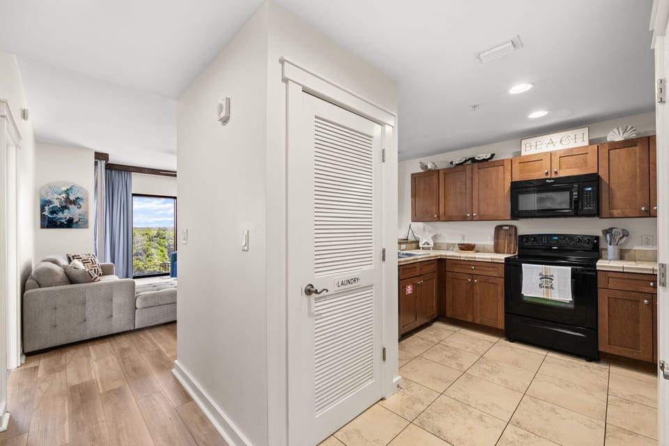 Step into your fully equipped kitchen with warm wood cabinetry, modern appliances, and a convenient in-unit laundry. Soaring vaulted ceilings and an open layout welcome you home.