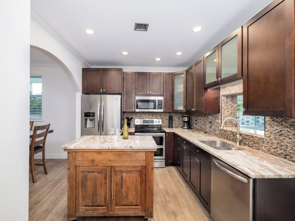 Experience the joy of cooking with a fully equipped kitchen, rich wood cabinetry, and the perfect backdrop for your vacation