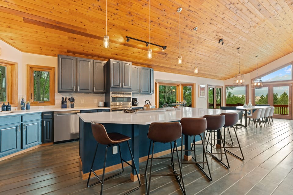 Gather around this spacious kitchen island with stunning wood ceilings, modern appliances, and expansive windows framing natural views. You'll love preparing meals while soaking in the warm, inviting atmosphere and abundant natural light.
