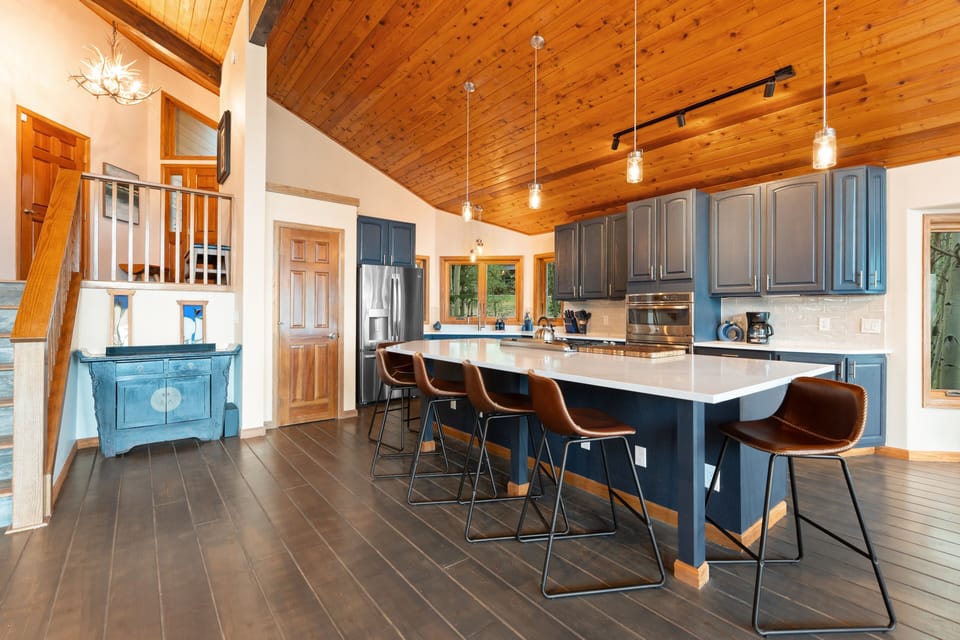 Gather around the spacious kitchen island where meals become memories. The vaulted wood ceiling, modern appliances, and abundant natural light create your perfect mountain retreat cooking space.