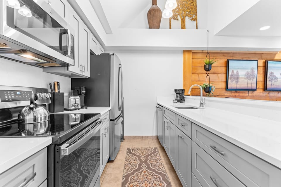 This modern kitchen offers everything you need to prepare meals with ease. Gleaming appliances and generous counter space make cooking a pleasure, while the sleek design creates a welcoming space to gather and enjoy.