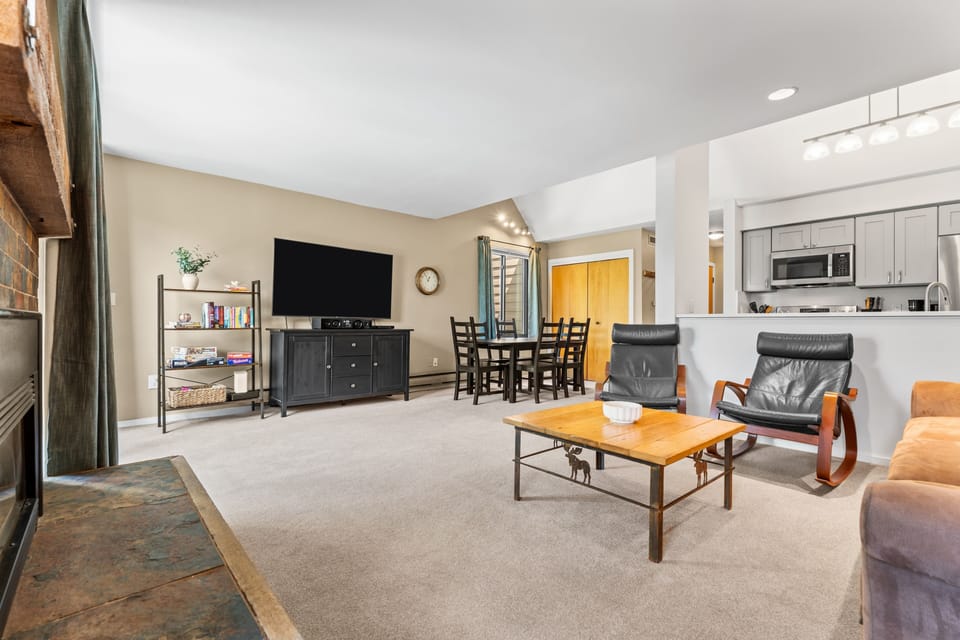 Relax in your spacious open-concept living area with comfortable seating, a cozy fireplace, and a fully equipped kitchen ready for home-cooked meals. Gather around the dining table or unwind in front of the flat-screen TV after a day of adventure.