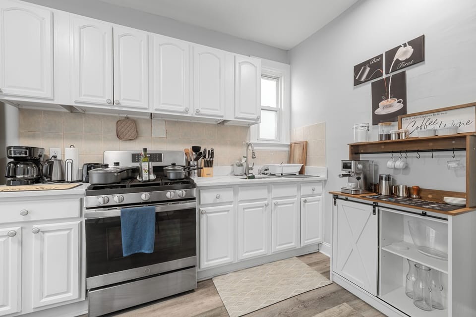 Bright full kitchen with coffee bar and stylish white cabinetry