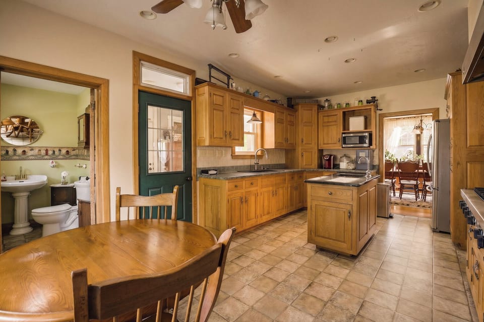 The kitchen is located right by the mudroom/rear entrance of the house. 