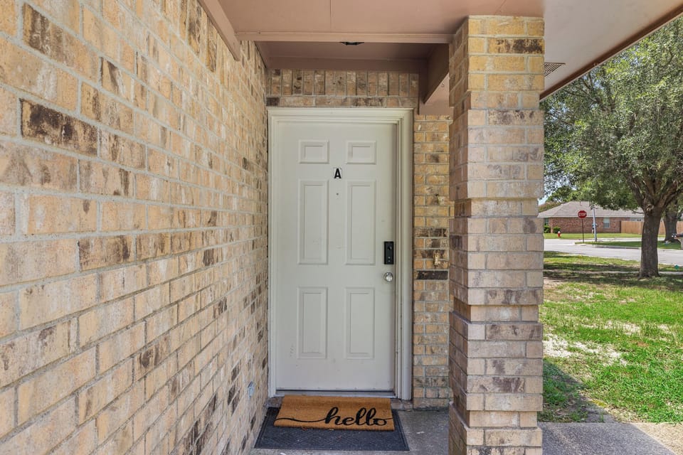 Welcoming covered front entry with charming brick exterior