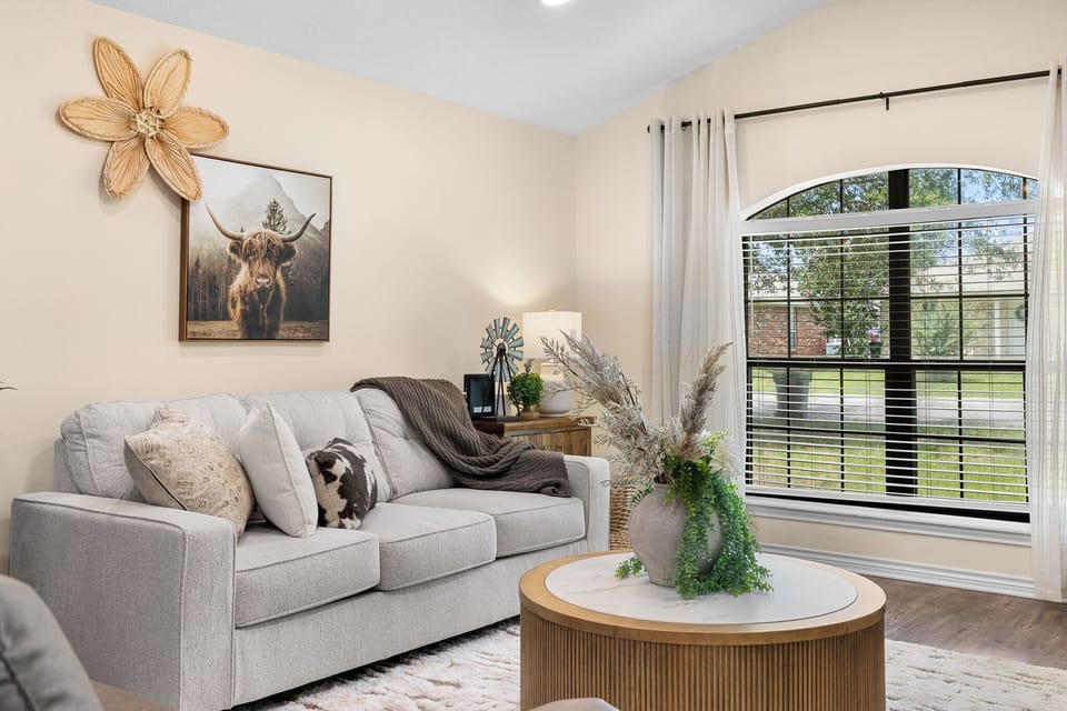 Bright, cozy living room with arched window and stylish rustic decor