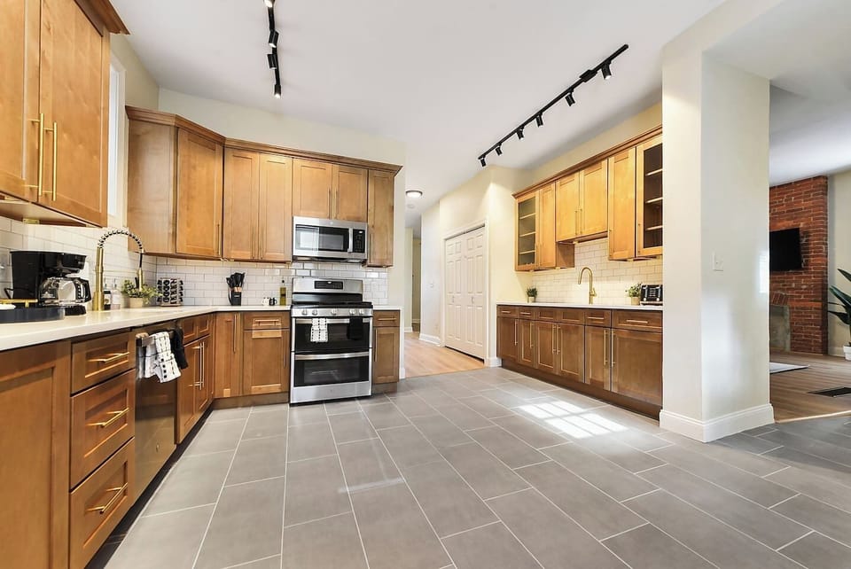 Well-equipped kitchen featuring brand-new stainless steel appliances and ample cabinet storage