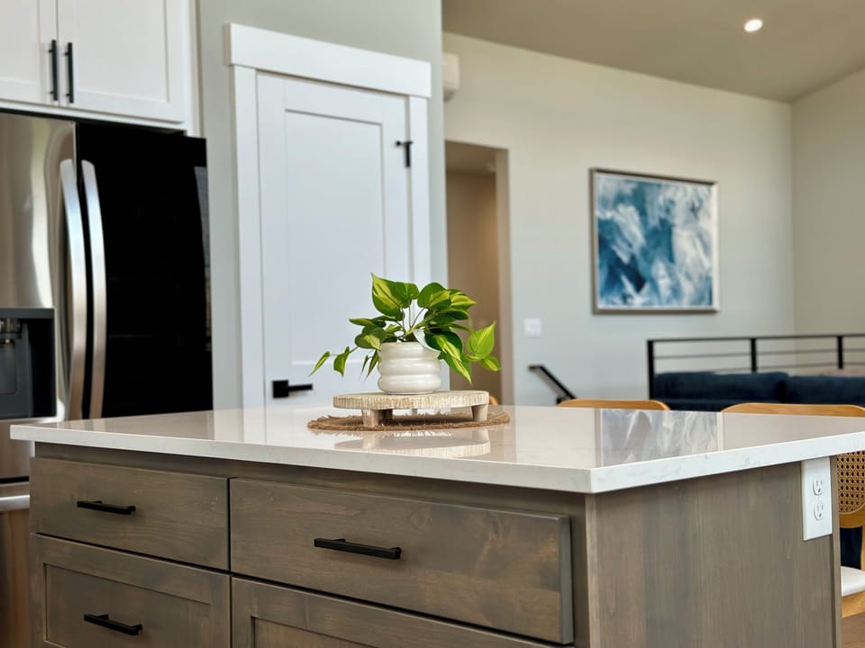 Pull up to the island for early coffee; it opens straight onto the living room, so the cook stays part of the conversation.