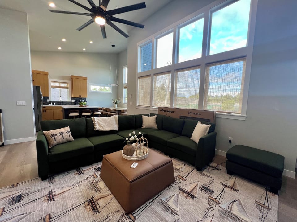 Up on the main level, soaring vaulted ceilings and walls of windows fill the open living space with light.