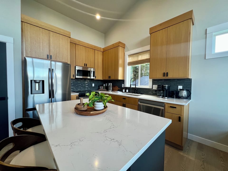 A gorgeous quartz island anchors the kitchen — gather, snack and pour your favorite drink.