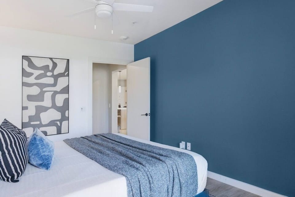 Bedroom 2 features a King bed with a full-length mirror and access to the private balcony.