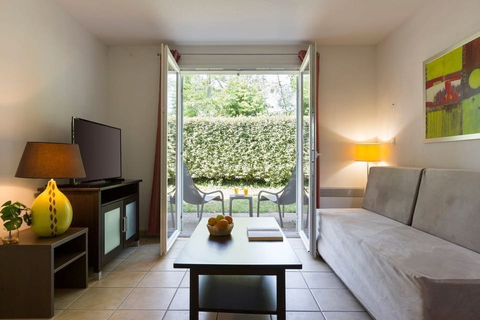 Sliding doors open directly onto the private terrace, connecting the living space with the outdoors — ideal for evening drinks in the Gascon air.