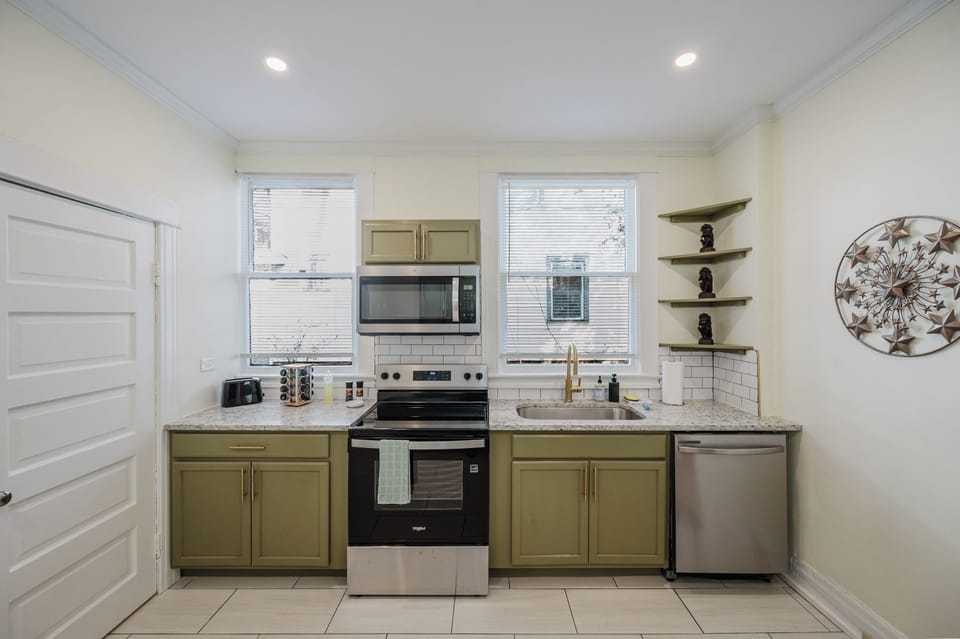 Bright windows and an open layout make the kitchen feel spacious and inviting, creating a comfortable place to cook, snack, or gather before heading out to explore Birmingham.