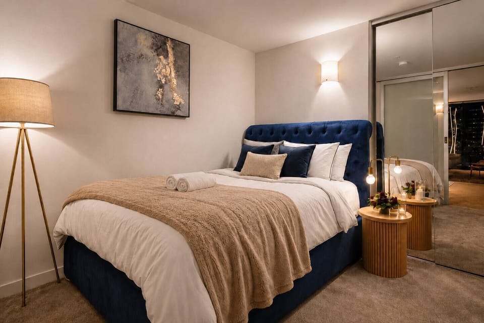Warm, softly lit bedroom with plush bedding, romantic ambience, and elegant cozy touches — perfect for a relaxing couples’ stay in the heart of the city.
