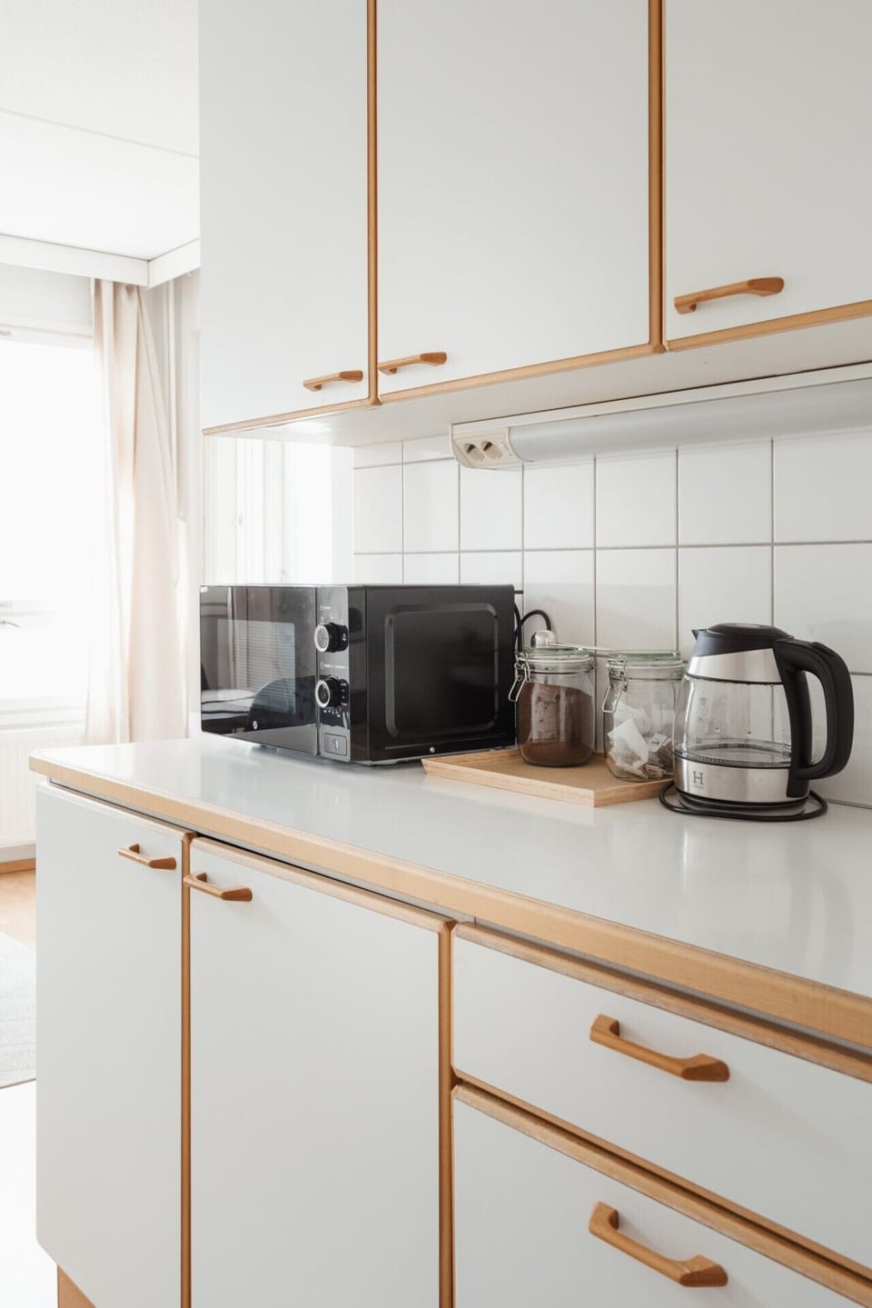 Kitchen counter with microwave, kettle and additional storage