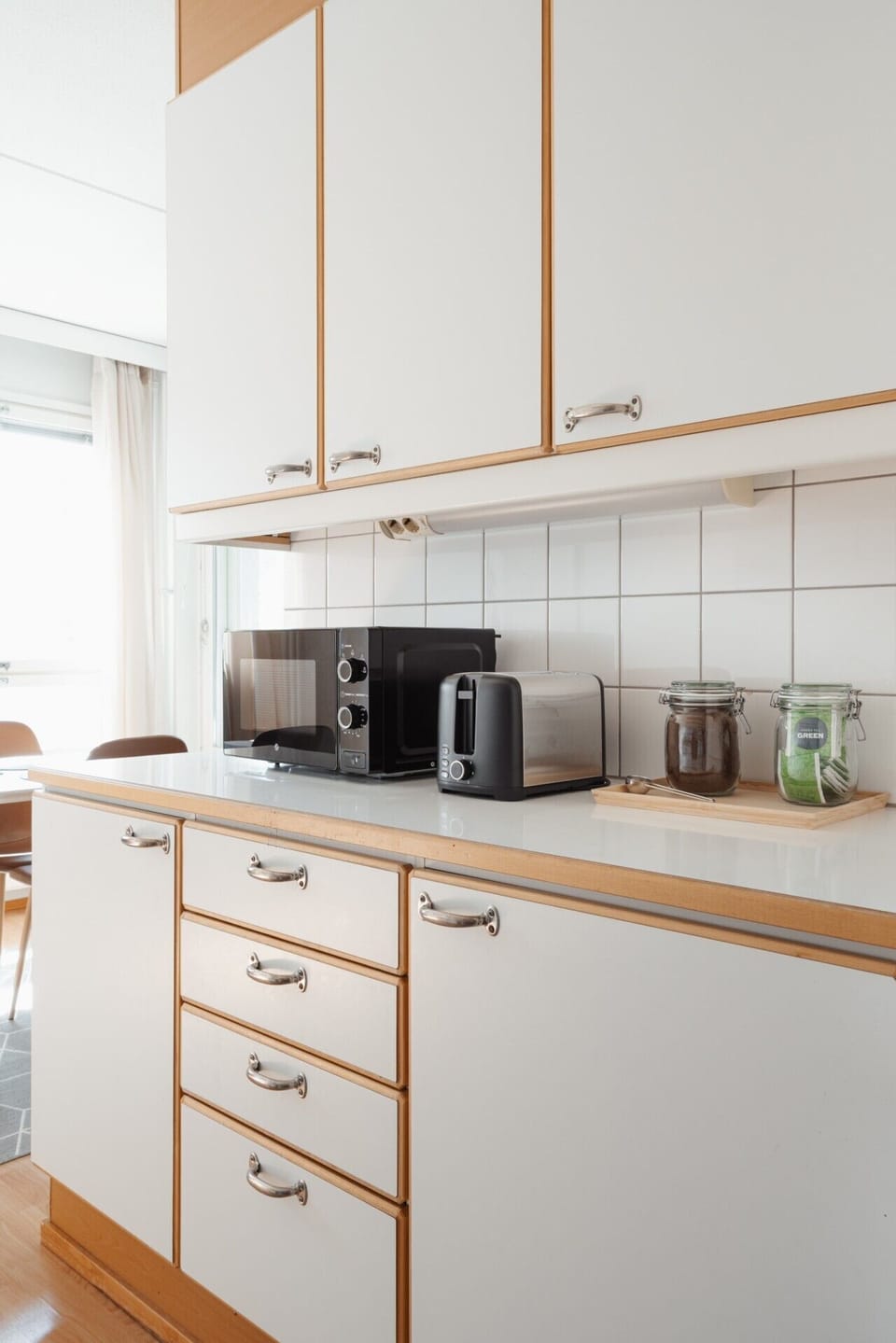 Kitchen counter with a built-in microwave and toaster under warm wooden cabinets.