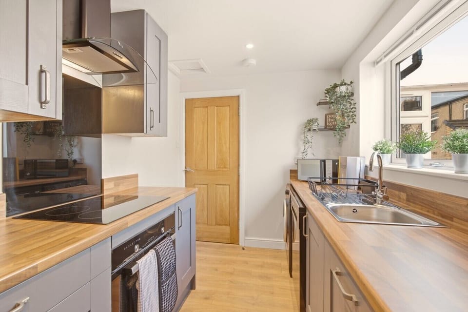 Kitchen with wooden worktops and integrated appliances.