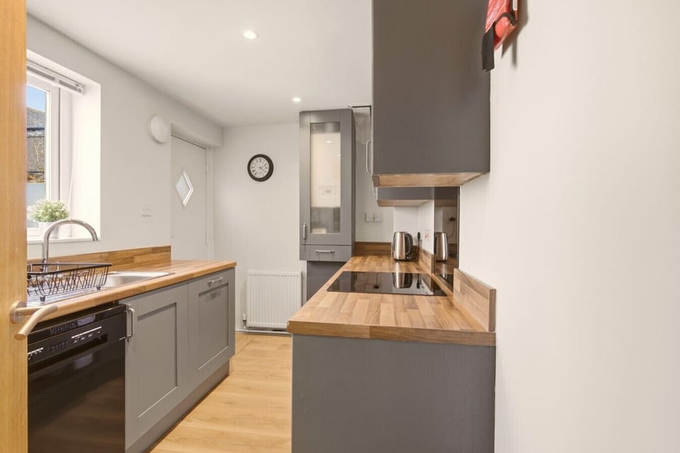 Galley kitchen with wooden worktops and grey shaker cabinets