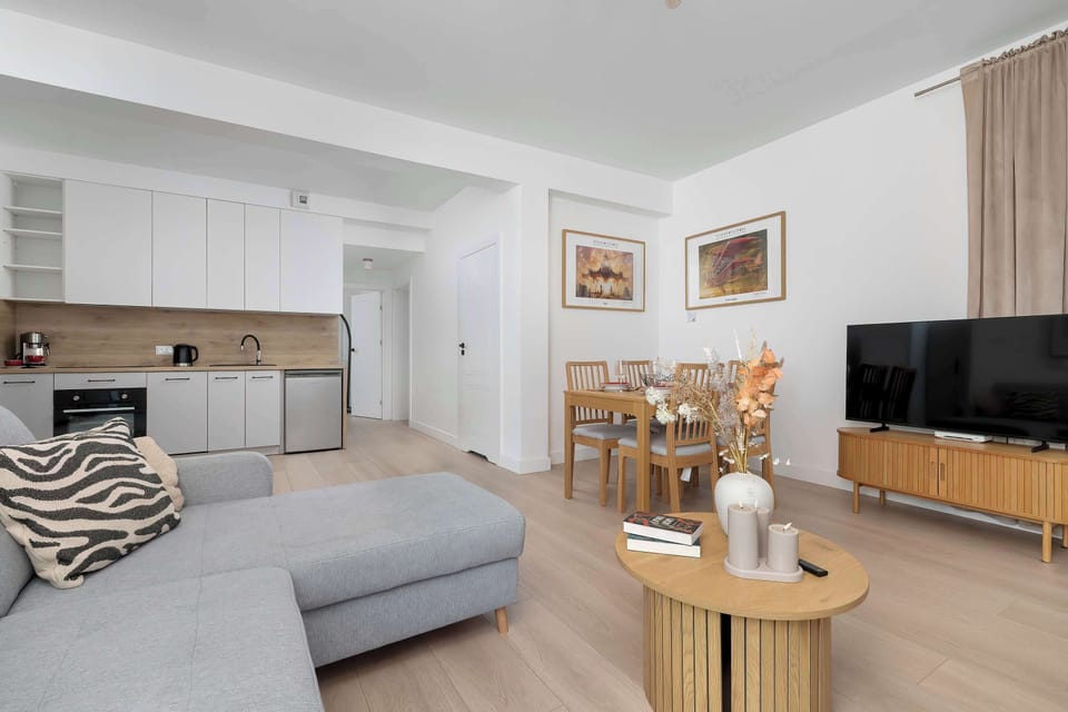 The living area features a sleek coffee table and a flat-screen television.