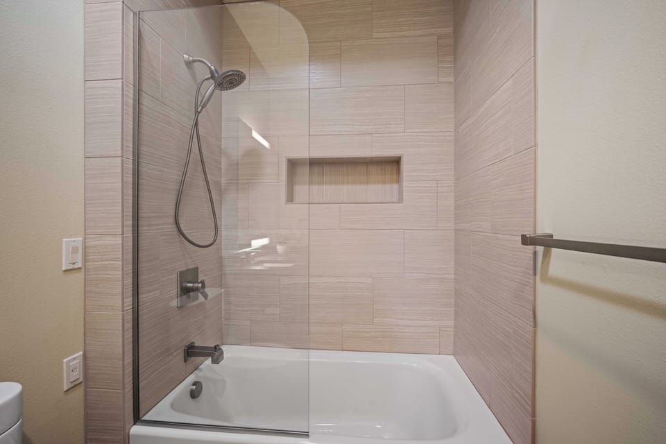 Slip into a deep tub and rinse away the day under a refreshing rainfall showerhead. The sleek tile surround and built-in niche keep your essentials close at hand.