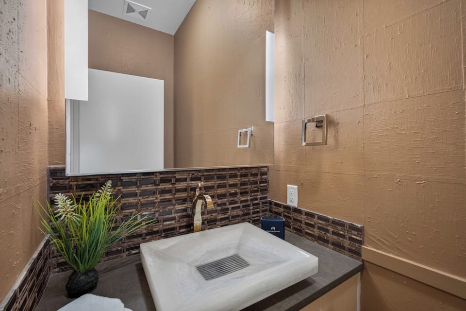 Refresh in your beautifully tiled half bath, where warm earth tones and modern fixtures create a stylish, inviting space just for you.