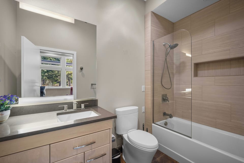 Refresh after your day in this modern bathroom with a sleek soaking tub, rainfall showerhead, and warm wood-toned tiles that create a spa-like retreat.