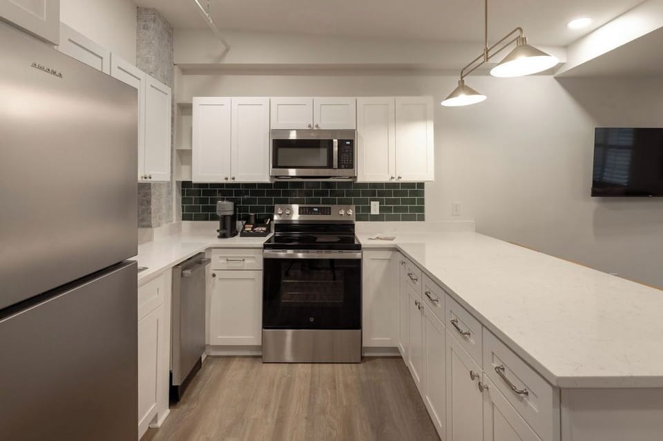 Modern kitchen with quartz counters, stainless appliances, and breakfast bar